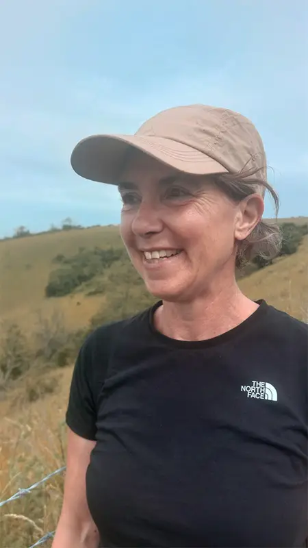 Rachel Attmere smiling, in a hat, on the South Downs